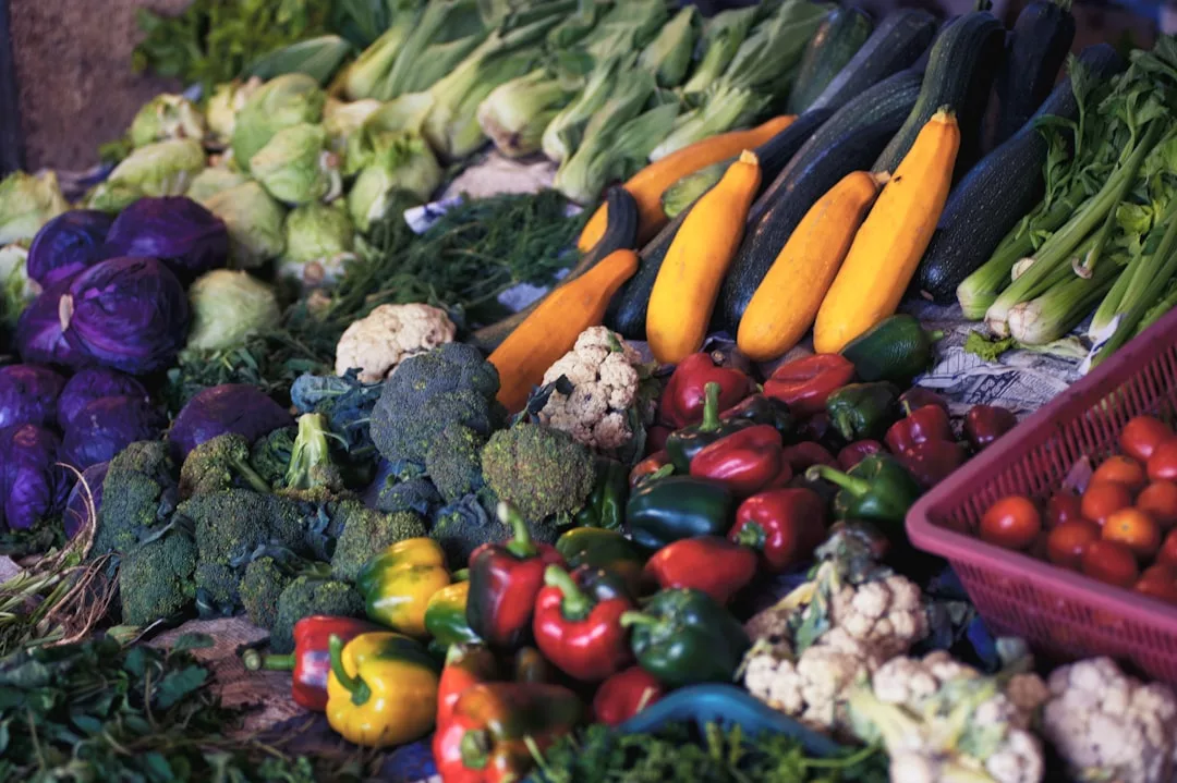 Eine Vielfalt an frischem Gemüse, darunter Paprika, Brokkoli, Blumenkohl, Zucchini, Tomaten, Mais und Kohl, auf einem Markttisch auf Mallorca.