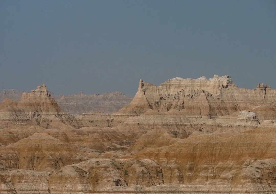 In dieser eindrucksvollen Wüstenlandschaft erheben sich unter einem strahlend blauen Himmel schichtweise Felsformationen und schroffe Klippen, die an Mallorca erinnern.