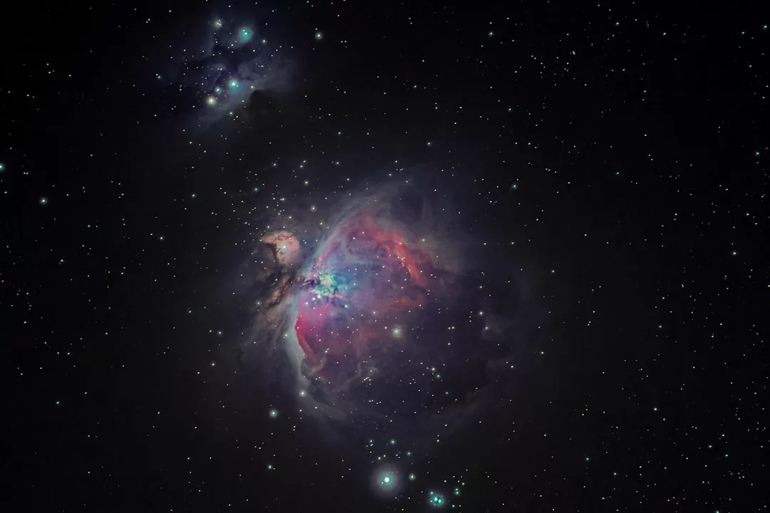 Ein hochauflösendes Bild des Orionnebels zeigt leuchtende Gas- und Staubwolken, die an die farbenprächtigen Sonnenuntergänge auf Mallorca erinnern, umgeben von zahlreichen Sternen vor einem dunklen Weltraumhintergrund.